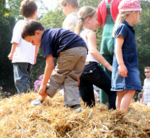 Kinder spielen auf einem Heuhaufen, Foto Landwirtschaftskammer RLP Kinder spielen auf einem Heuhaufen, Foto Landwirtschaftskammer RLP