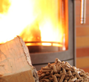 Pellets und Holzscheit vor einem Ofen, Foto: fotolia Pellets und Holzscheit vor einem Ofen, Foto: fotolia