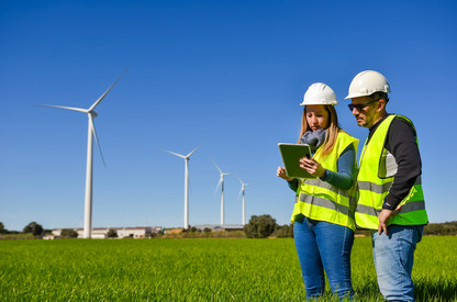 Interaktive Karte Menschen arbeiten auf Tablet im Geländer vor Windrädern