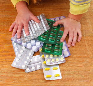 A small child playing with medicines. Kinderhände greifen nach Medikamenten