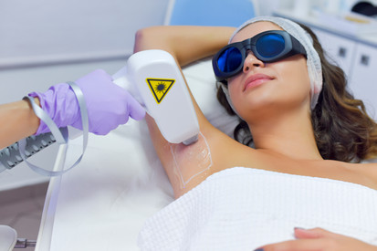 Nichtionisierende Strahlung Frau mit Sicherheitsbrille erhält Laserbehandlung im Achselbereich