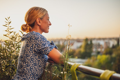 Digitale Chancen für Klima- und Umweltschutz nutzen Frau genießt Ausblick von ihrem Balkon